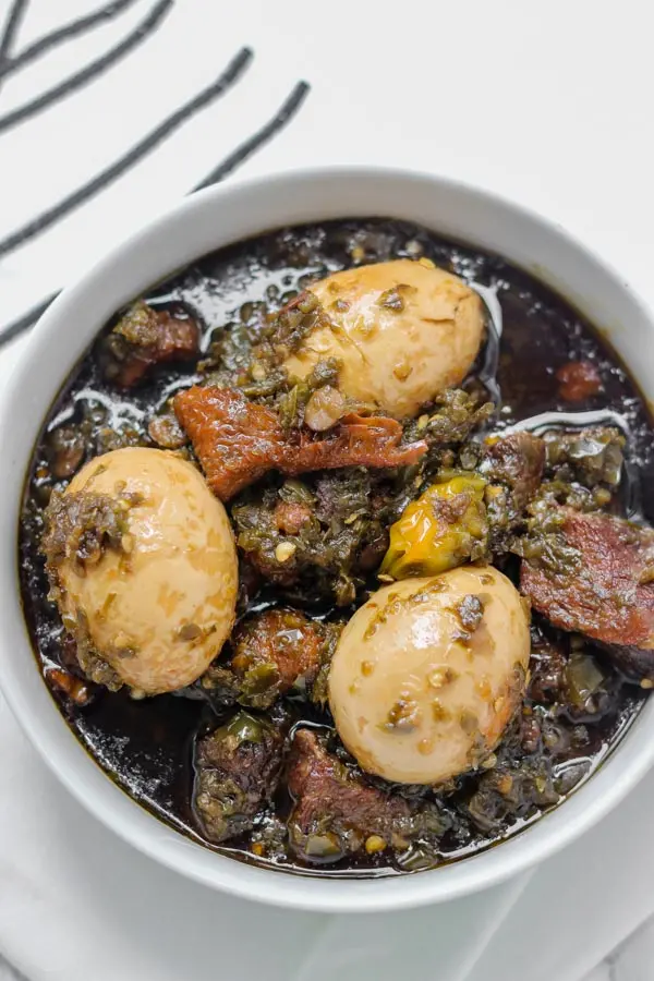 Ayamase Stew Nigerian green pepper designer stew with assorted meat, boiled eggs, and bleached palm oil, served with ofada rice