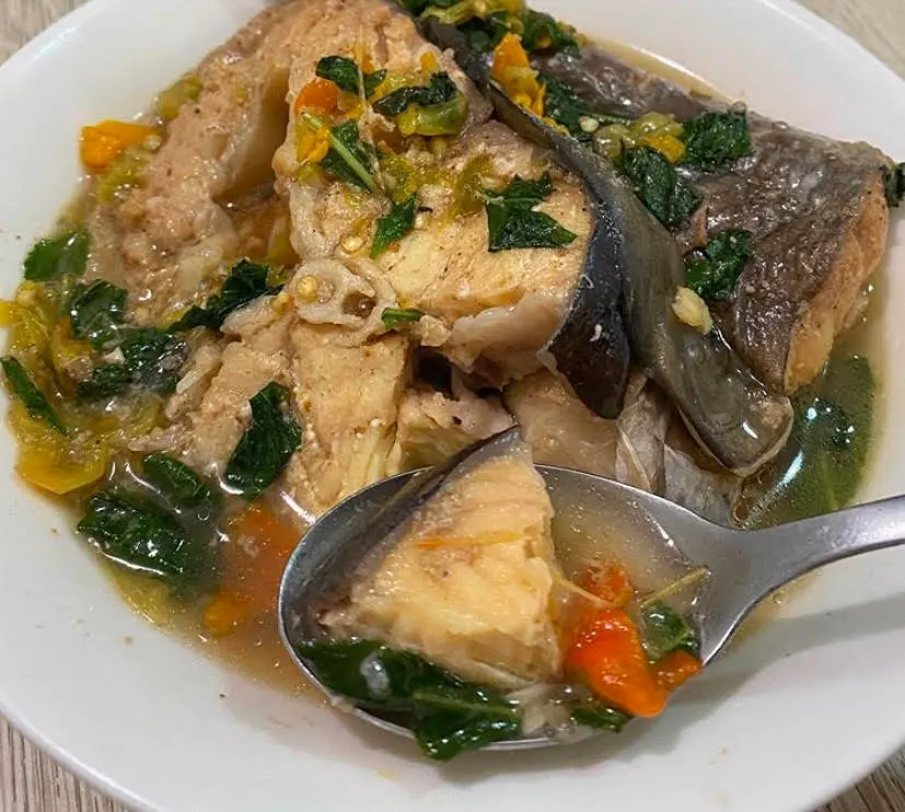 Nigerian Catfish Pepper Soup in a bowl with whole catfish pieces and pepper soup spices, a classic Nigerian restaurant dish