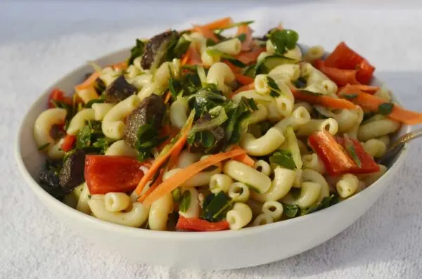 Zogale Nigerian moringa leaf salad served with macaroni, groundnut paste, and spices, a northern Nigerian Hausa dish