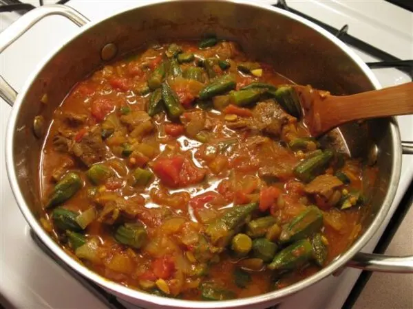 Bamia Egyptian okra stew in a pot with lamb and tomato sauce, a traditional North African dish served with rice