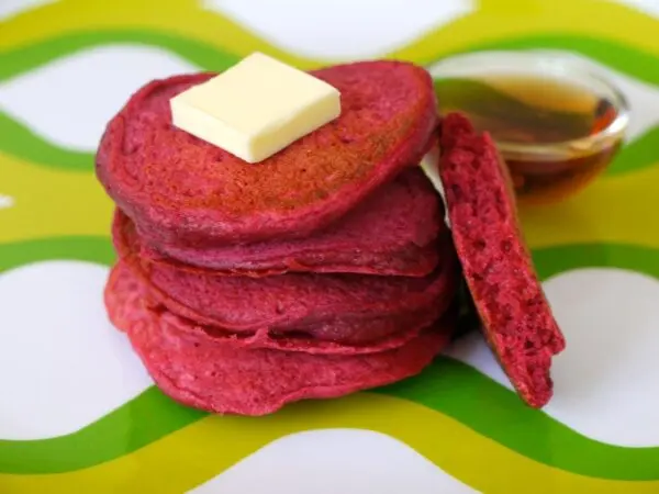 South African Beetroot Pancakes stacked on a plate, naturally coloured pink from roasted beetroot with maple syrup