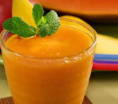 Fresh Nigerian Papaya Juice in a glass with ice and lime, a smooth natural tropical drink from ripe pawpaw