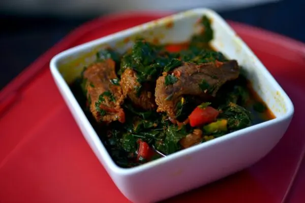 Efo Riro spinach stew served in a pot with assorted meat and dried fish, a classic Yoruba dish from southwestern Nigeria