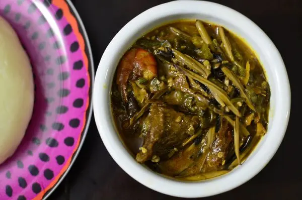 Ofe Ugba Nigerian oil bean soup in a pot with fermented ugba seeds, palm oil, and assorted meat from eastern Nigeria