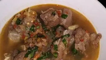 Nigerian Potato Pepper Soup in a bowl with fish and mushrooms, a spiced West African soup flavoured with traditional pepper soup spices