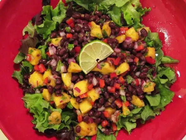Mango and pineapple salad served on lettuce with strawberries