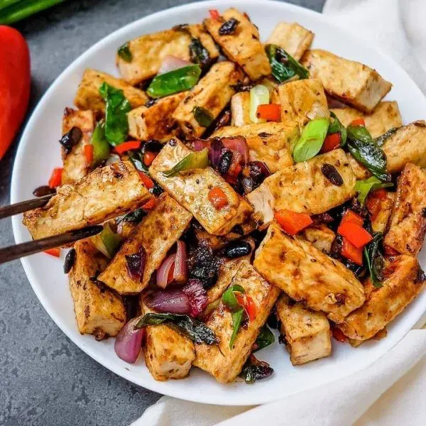 Awara, a Northern Nigerian fried soy bean cake, served hot with pepper and sliced vegetables