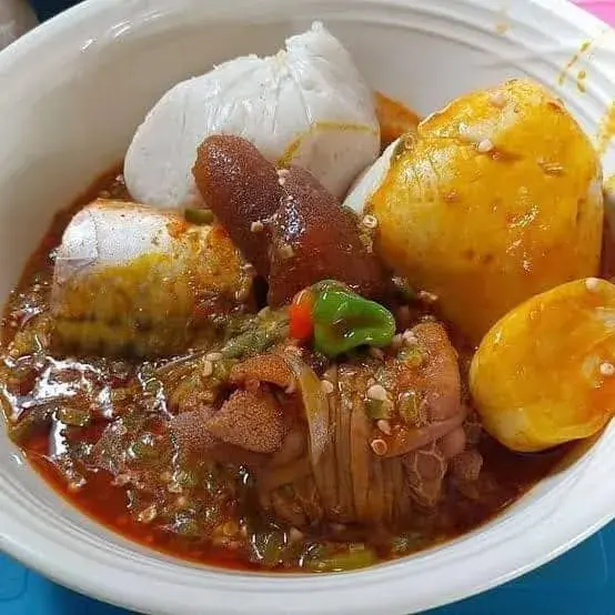 Banku, a Ghanaian fermented corn and cassava dish, shaped into balls and served with grilled tilapia and pepper sauce