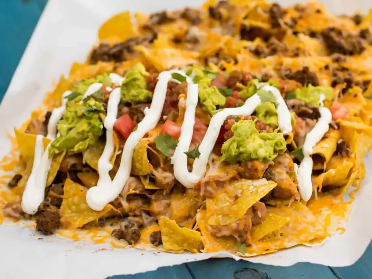 Beef nachos supreme with melted cheese, diced onion, pepper and avocado