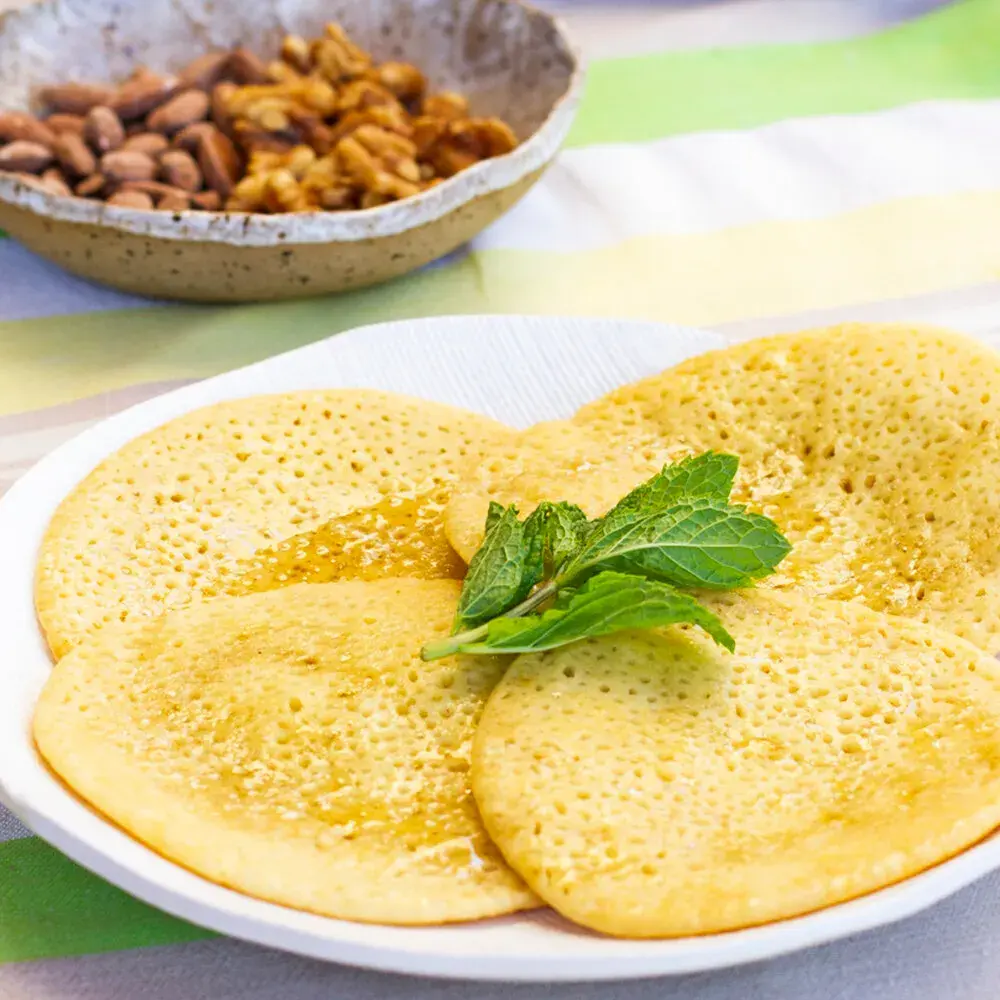 Beghrir, Moroccan semolina pancakes covered in small holes, with honey butter