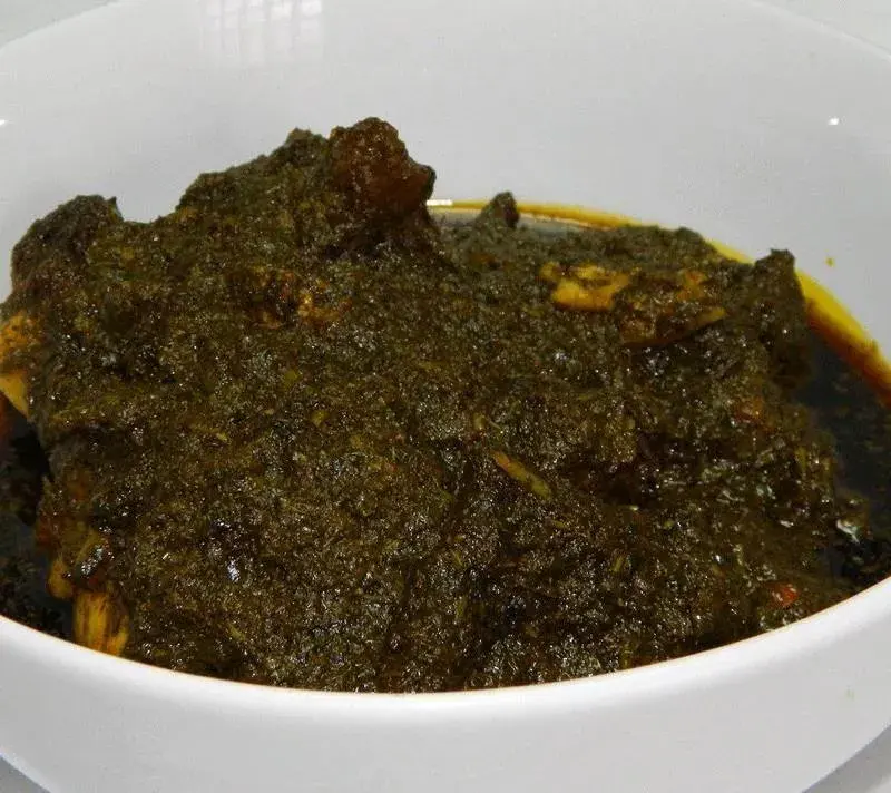 Cassava leaf soup, a West African stew of cassava leaves with groundnut and palm oil, served over rice