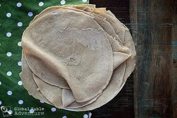 Kisra, thin fermented sorghum flatbread from Sudan stacked on a plate