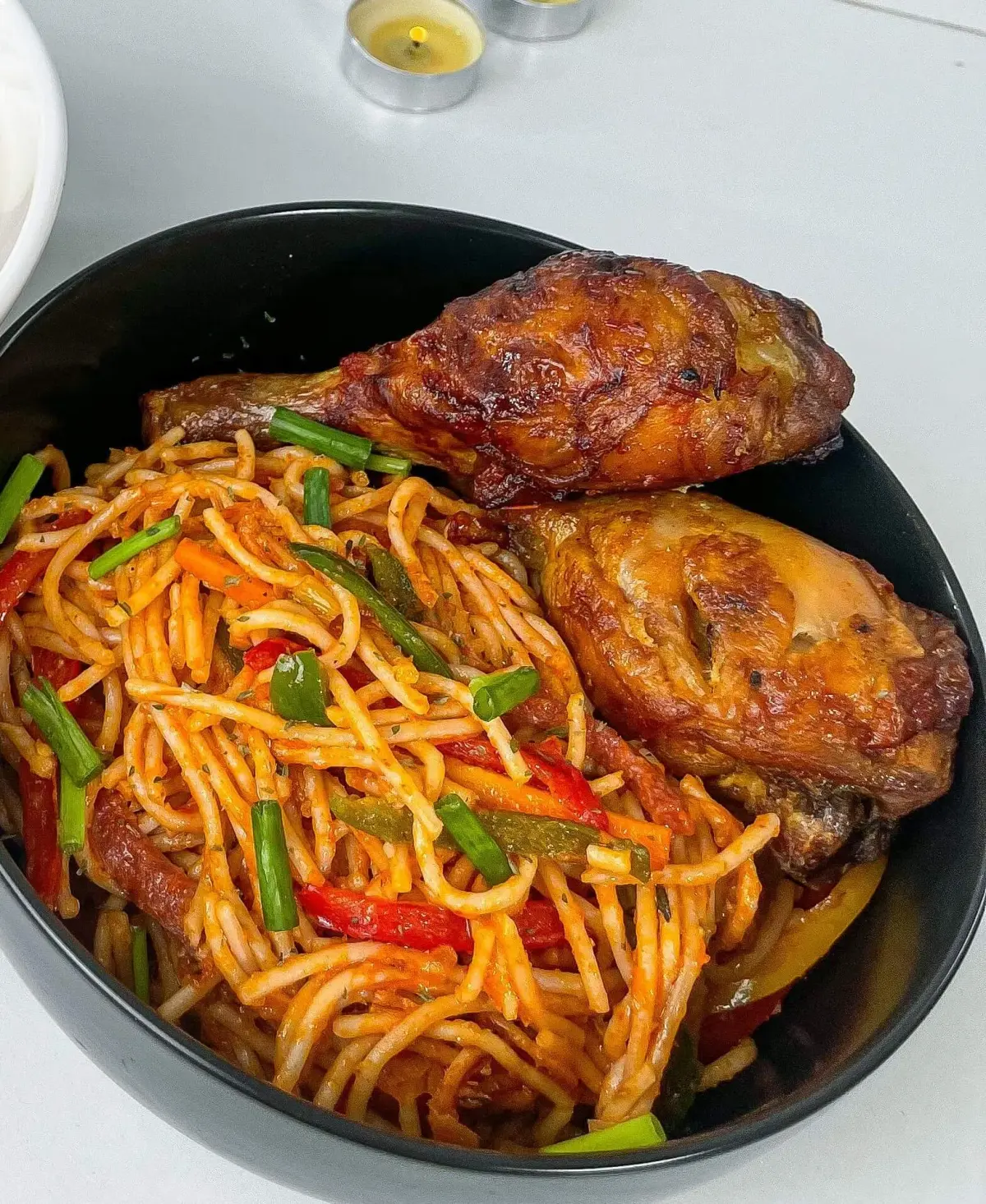 Nigerian jollof spaghetti cooked in a blended pepper sauce with sausage, bell pepper and carrot