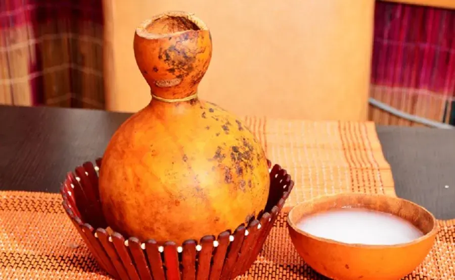 Palm wine cocktail served over ice with orange slices and berries