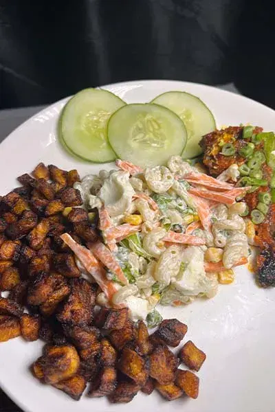 A Nigerian style pasta salad with macaroni, carrots, sweetcorn, peas and boiled egg in a mayonnaise dressing