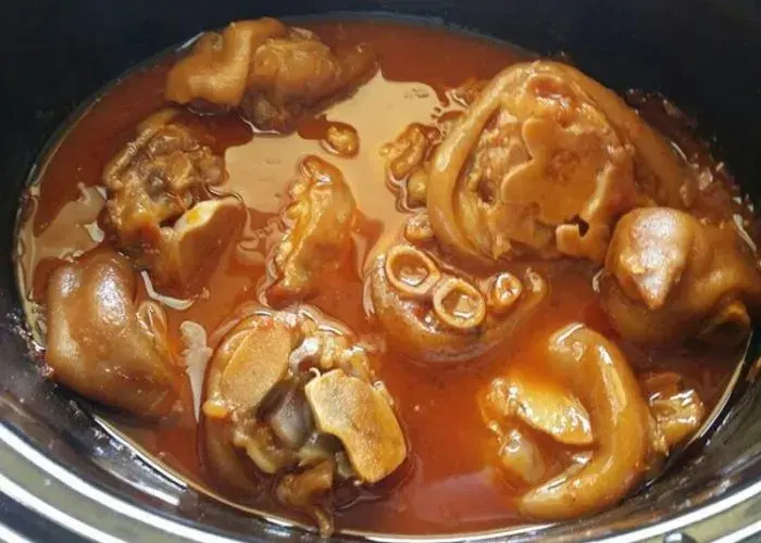 South African pig trotters slow cooked in a tomato and onion gravy and served with pap