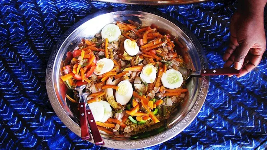 Thiébou yapp, a Senegalese rice dish cooked in seasoned broth with beef and chicken and served on a communal platter