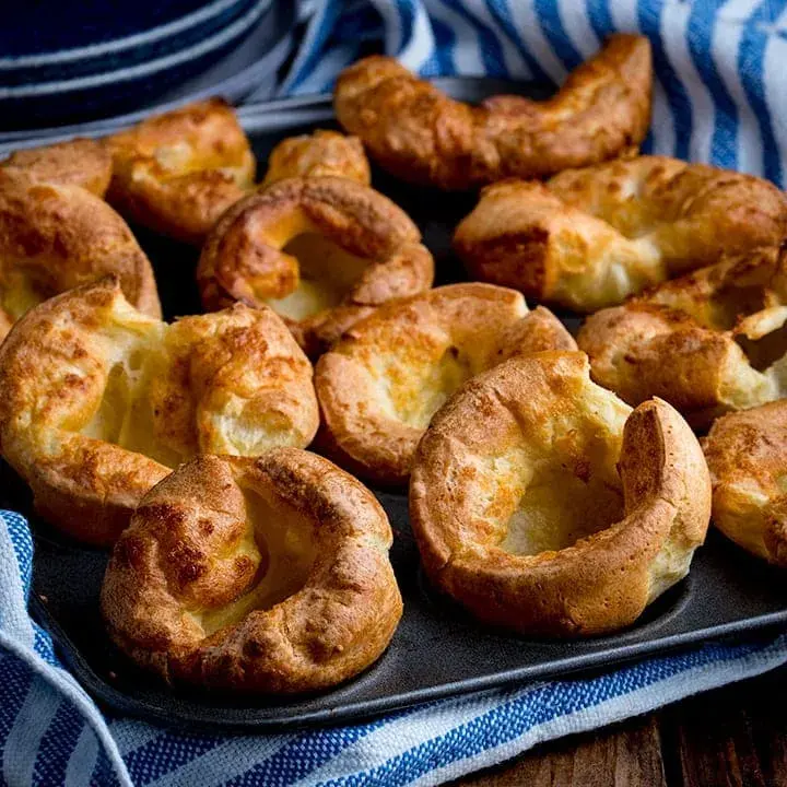 Yorkshire puddings risen tall and golden in a muffin tin