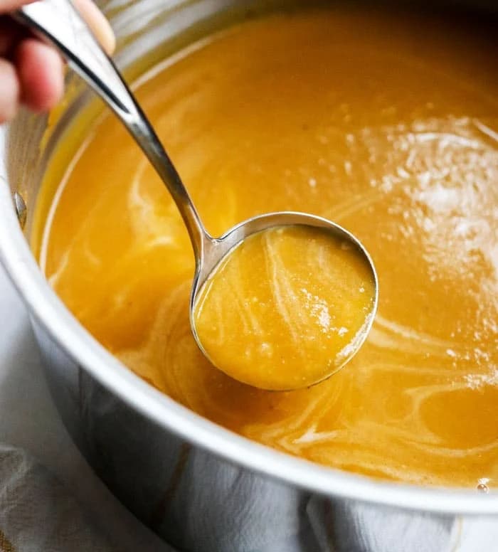 South African Butternut Soup in a bowl with cream swirl and toasted seeds, a creamy roasted squash soup