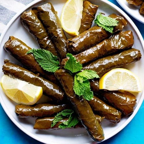 Egyptian Dolma stuffed grape leaves arranged in a pot, rolled vine leaves filled with spiced rice cooked in lemony broth