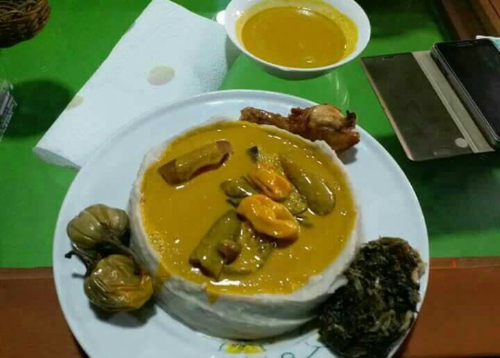 Cameroonian Achu Soup yellow soup with meat and spices in a bowl served with pounded cocoyam, a Northwest Cameroon celebration dish