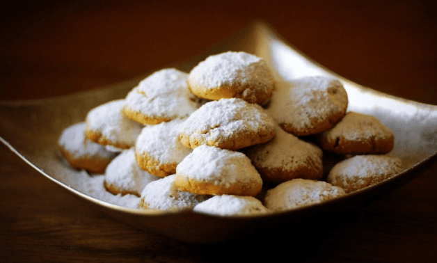 Egyptian Kahk Eid cookies dusted with icing sugar on a plate, traditional Egyptian celebration biscuits filled with nuts