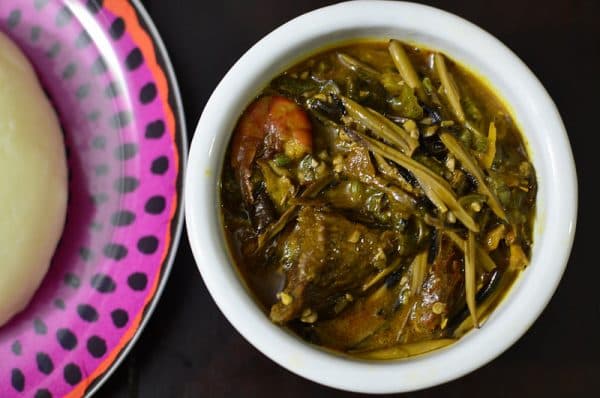 Ofe Ugba Nigerian oil bean soup in a pot with fermented ugba seeds, palm oil, and assorted meat from eastern Nigeria