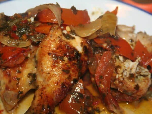 Poulet Fafa served on a plate with green taro leaf sauce and rice, a Togolese chicken dish with West African coastal influence