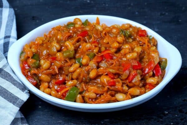 Chakalaka South African spicy vegetable relish served in a bowl with carrots, peppers, and baked beans