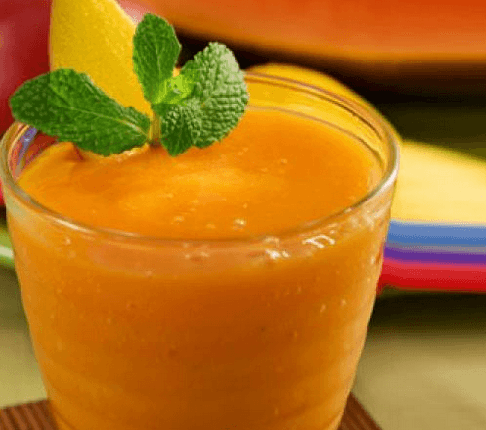 Fresh Nigerian Papaya Juice in a glass with ice and lime, a smooth natural tropical drink from ripe pawpaw