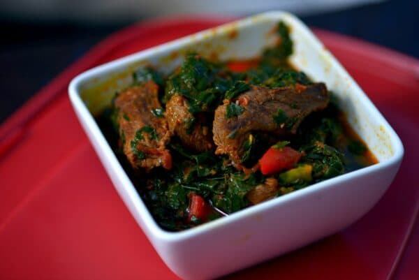 Efo Riro spinach stew served in a pot with assorted meat and dried fish, a classic Yoruba dish from southwestern Nigeria