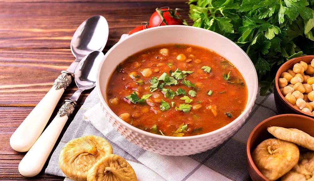 Algerian hariri, a rich lamb and chickpea soup served with lemon wedges