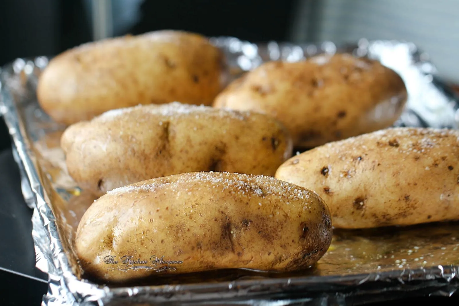 A baked potato with crisp salted skin and a fluffy interior