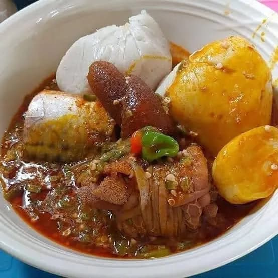 Banku, a Ghanaian fermented corn and cassava dish, shaped into balls and served with grilled tilapia and pepper sauce
