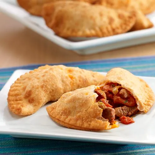 Crispy fried beef empanadas garnished with coriander