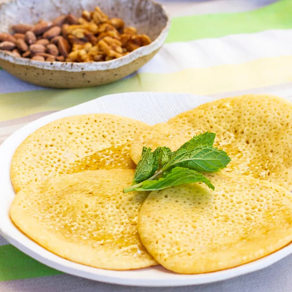 Beghrir, Moroccan semolina pancakes covered in small holes, with honey butter