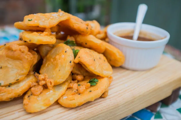 Bhajias, thin potato slices in spiced gram flour batter fried until crisp