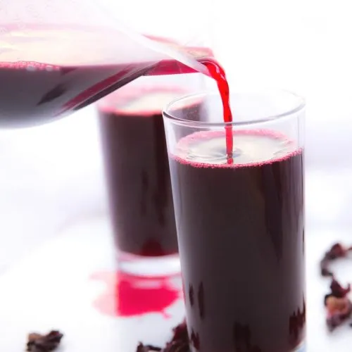 Bissap, a deep red Senegalese hibiscus drink served cold over ice with mint