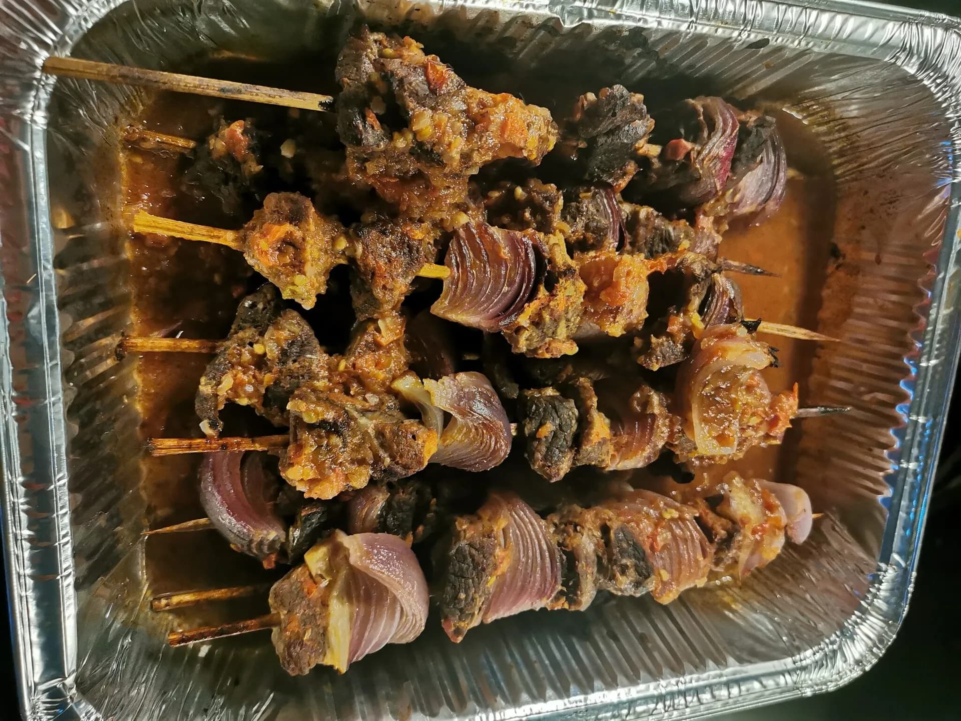 Rwandan brochettes, goat meat skewers grilled over charcoal and served with plantain and salad