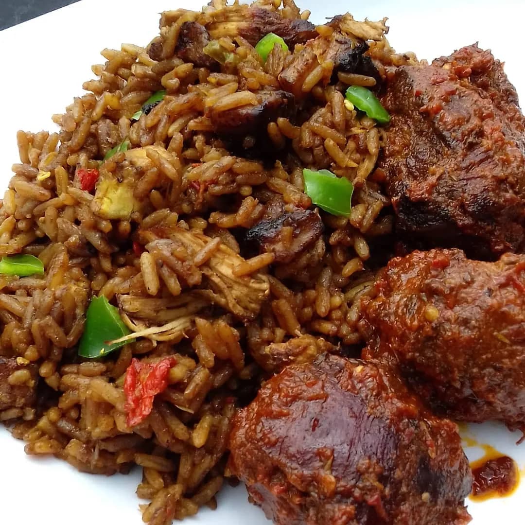Caribbean rice with chicken, beef, fried plantain and vegetables coloured with browning