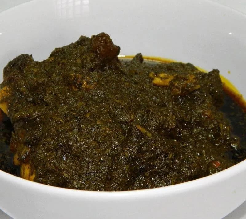 Cassava leaf soup, a West African stew of cassava leaves with groundnut and palm oil, served over rice