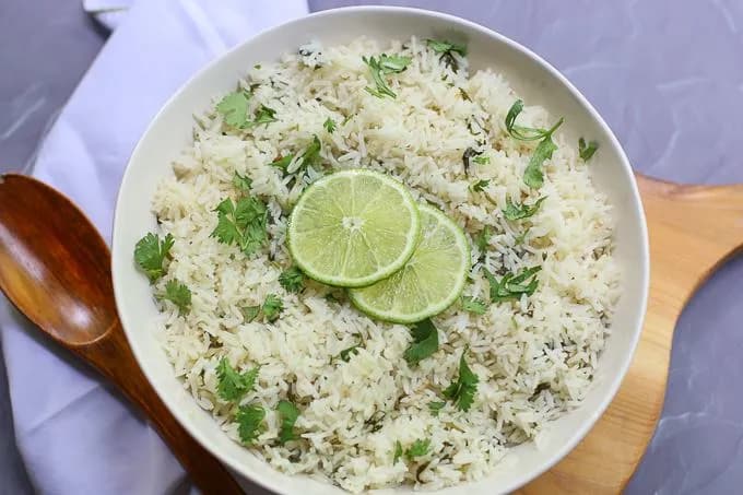 Coconut rice cooked in a rice cooker with peas and diced carrots