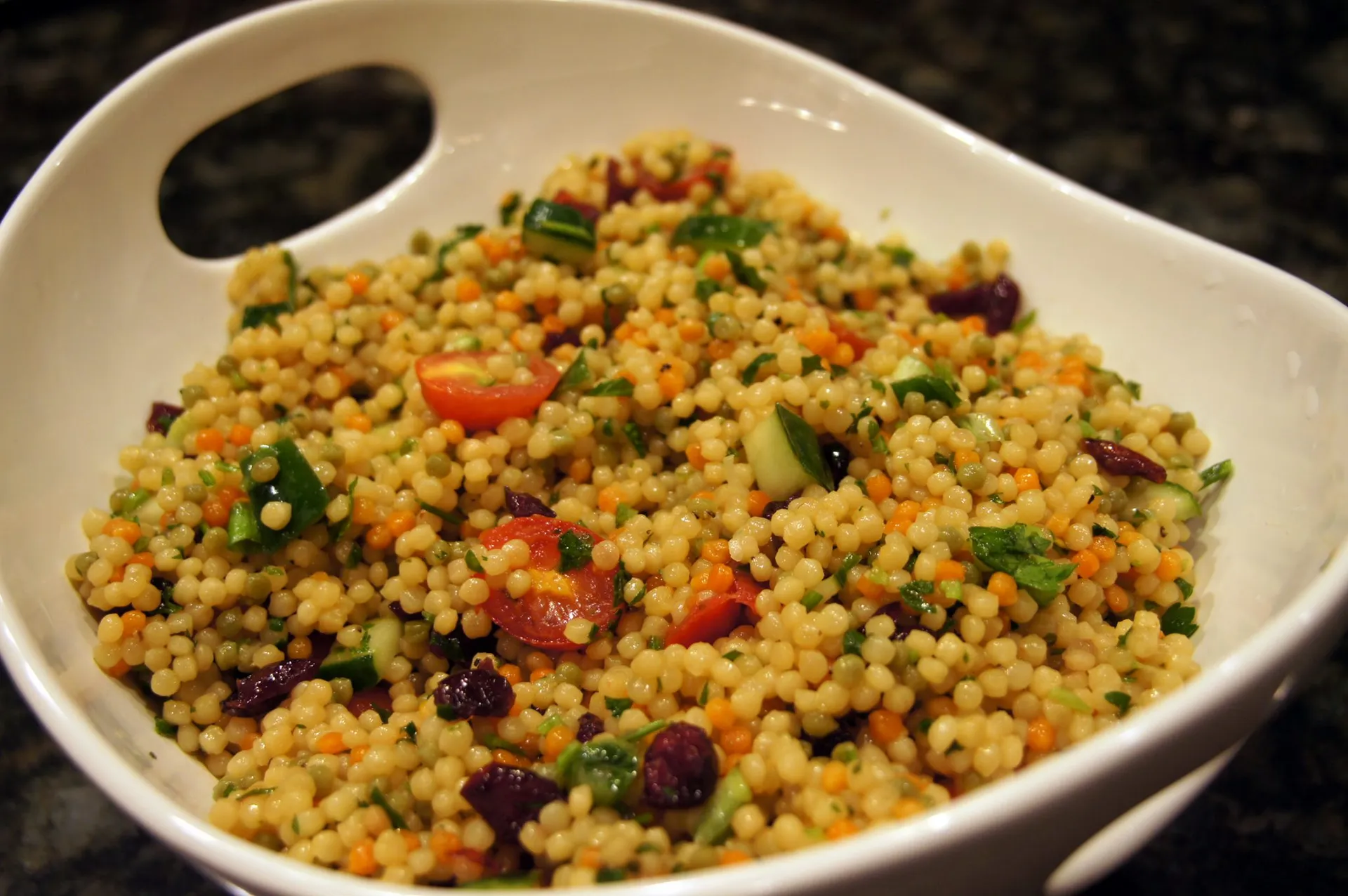Prepared couscous, fluffed with a fork in a bowl