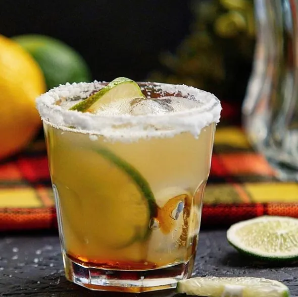 Dawa, a Kenyan lime and vodka cocktail served over ice with a honey stick