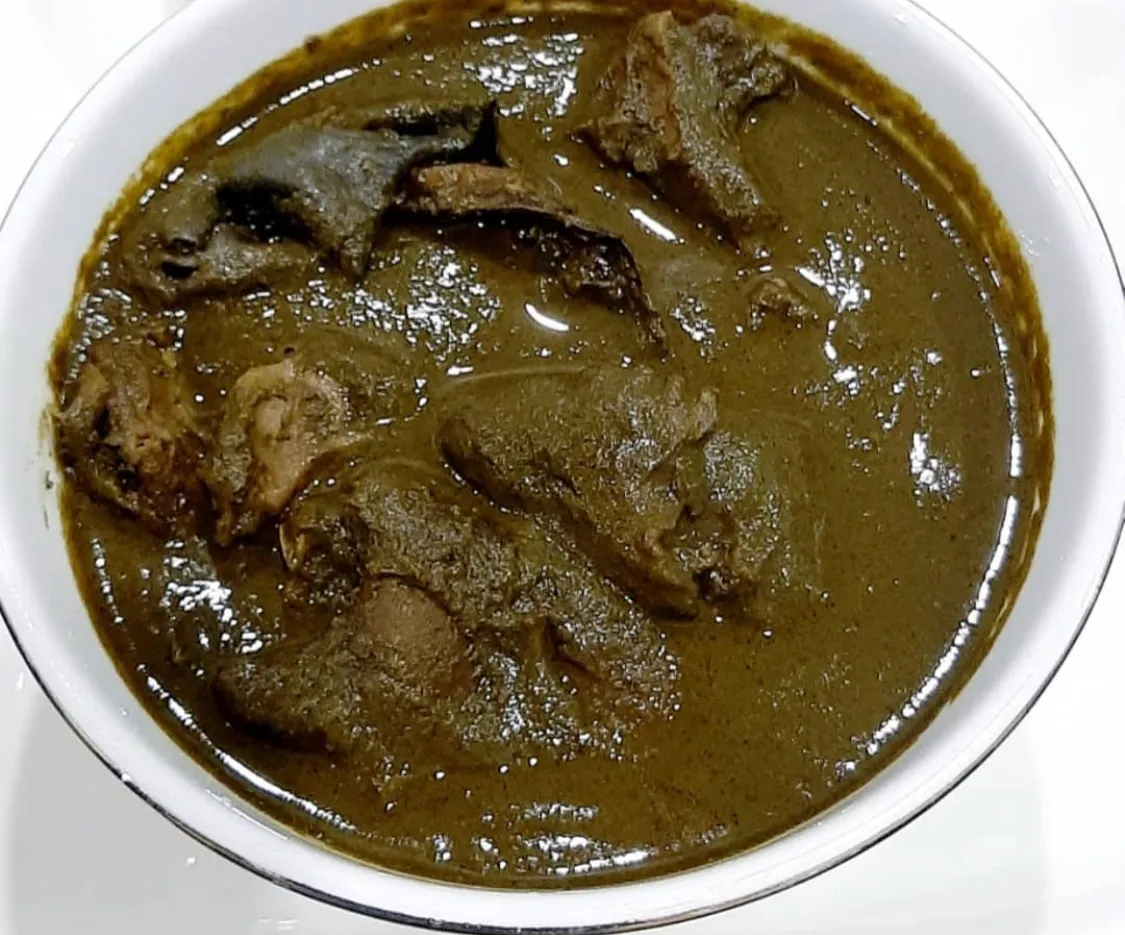 Edo Black Soup, a Nigerian soup of ground bitter leaf, scent leaf and uziza, served with pounded yam