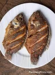 Fried whole tilapia, scored and spiced, crisped in a shallow pan