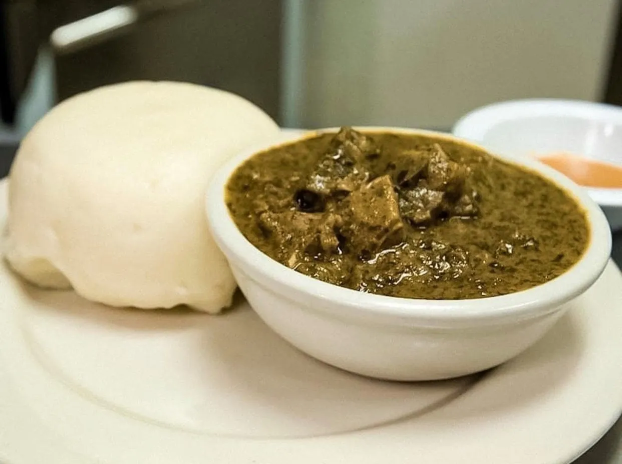 Isombe, a Rwandan stew of pounded cassava leaves with groundnuts, served with rice