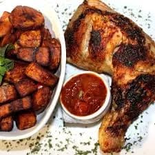 Ivorian alloco, fried plantain served with braised chicken and chilli sauce