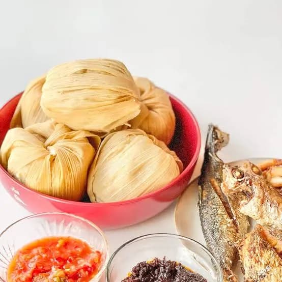 Kenkey, a Ghanaian fermented maize dough steamed in corn husks, served with fried fish and pepper sauce