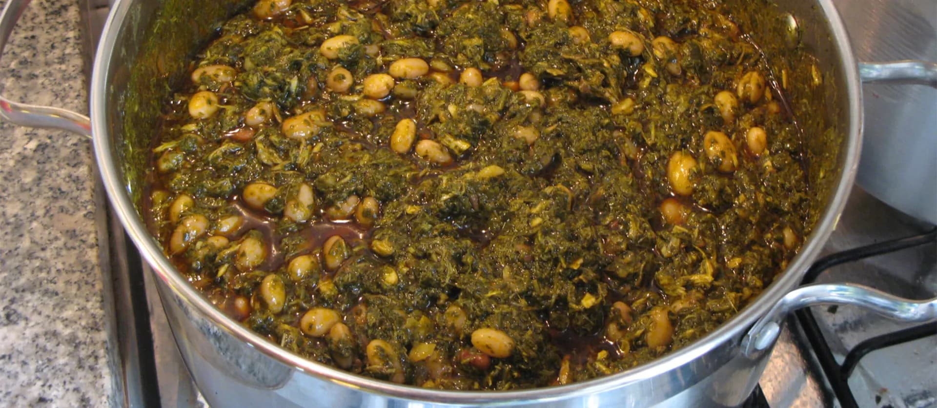 Kizaca, an Angolan dish of pounded cassava leaves cooked with groundnuts, served with white rice